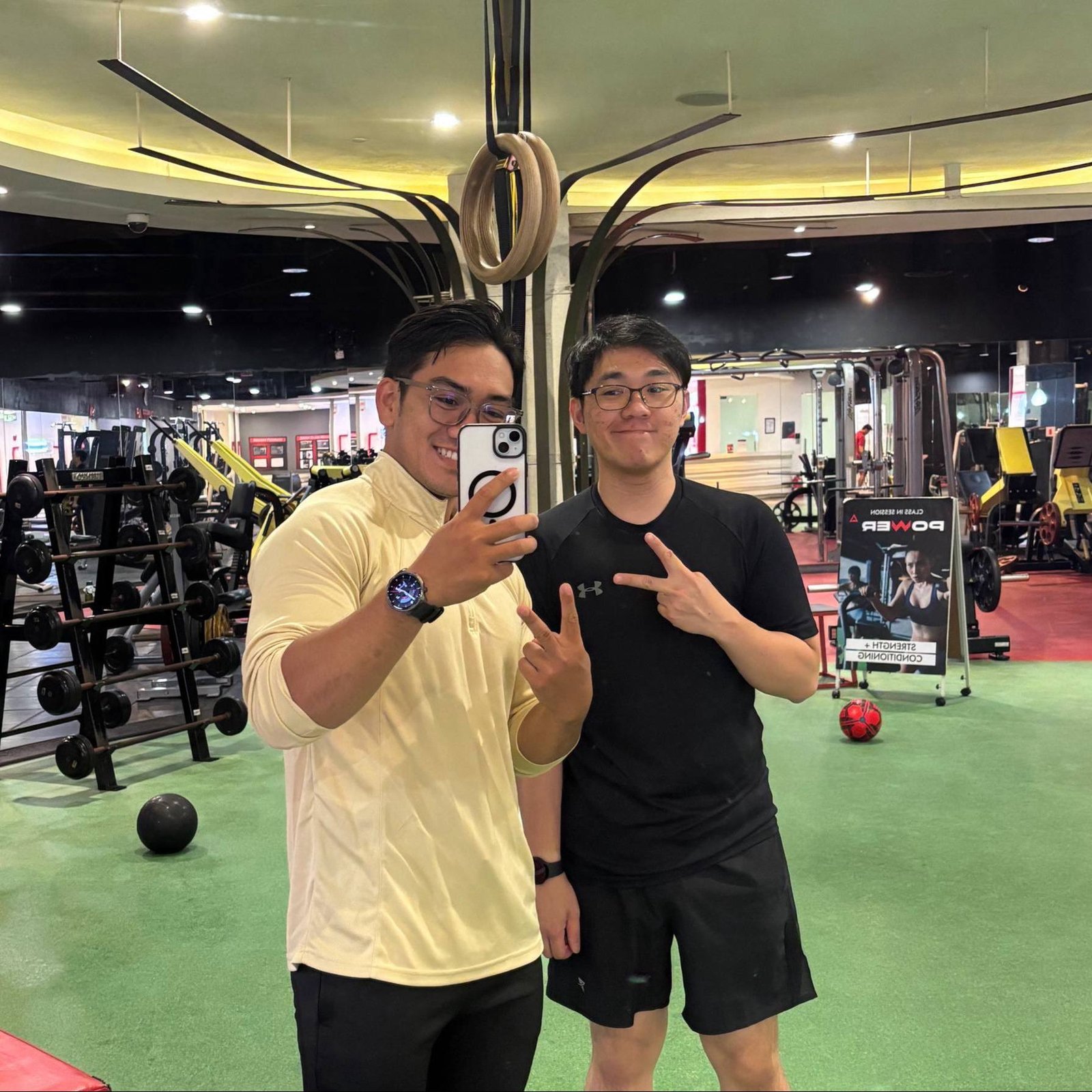 Faris and a client taking a photo at the gym