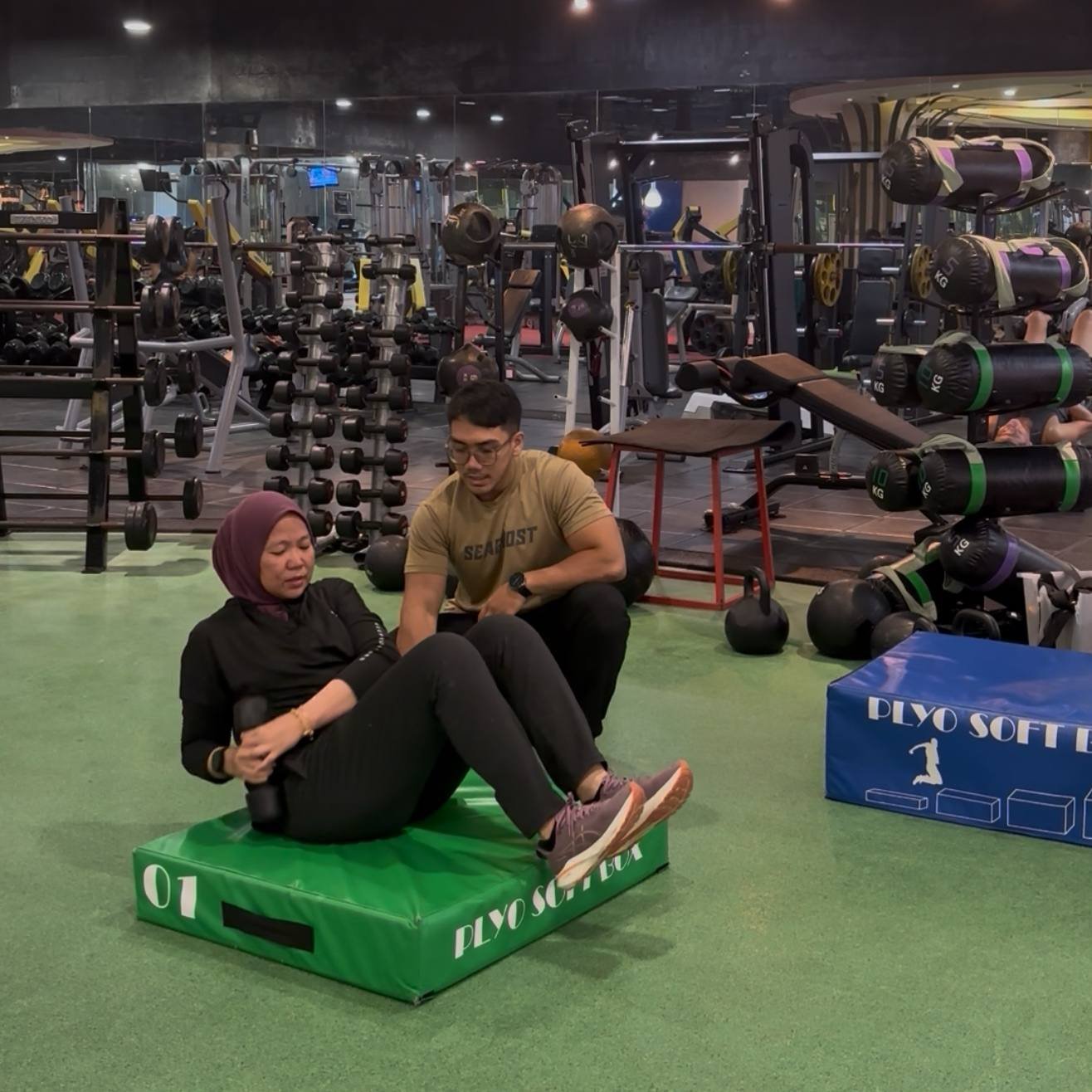 Faris supporting a client through seated core training