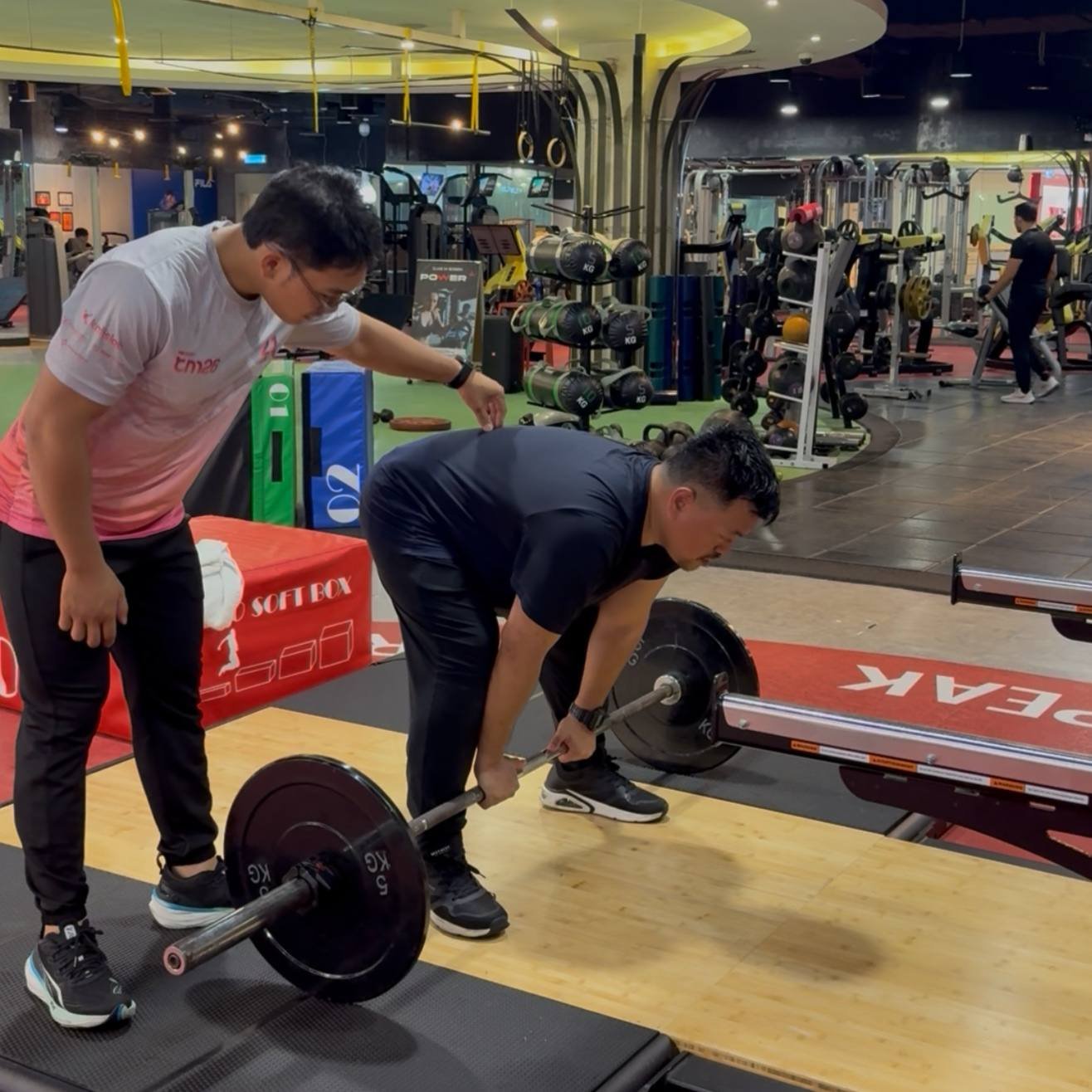 Faris guiding a client’s deadlift setup