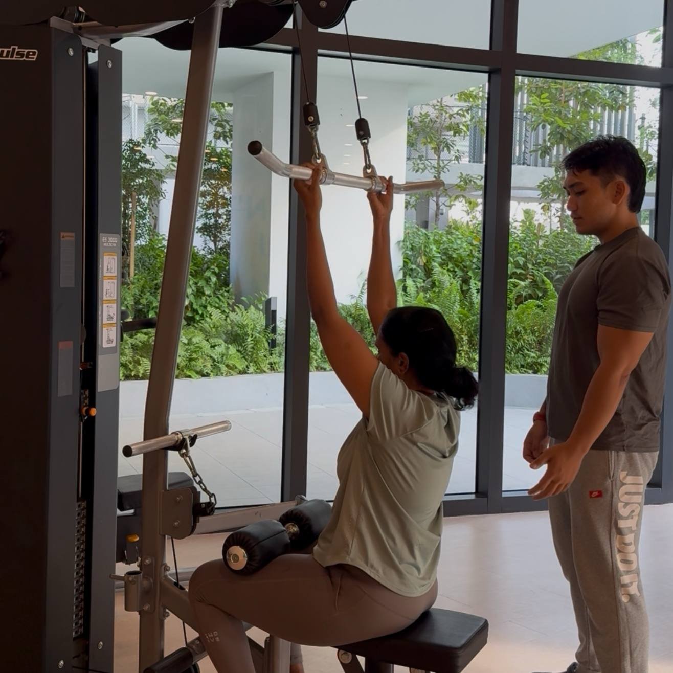 Faris guiding a client through a lat pulldown