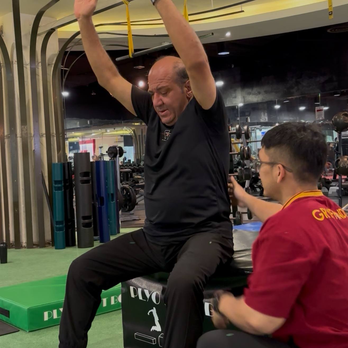 Faris observing a client’s seated overhead movement