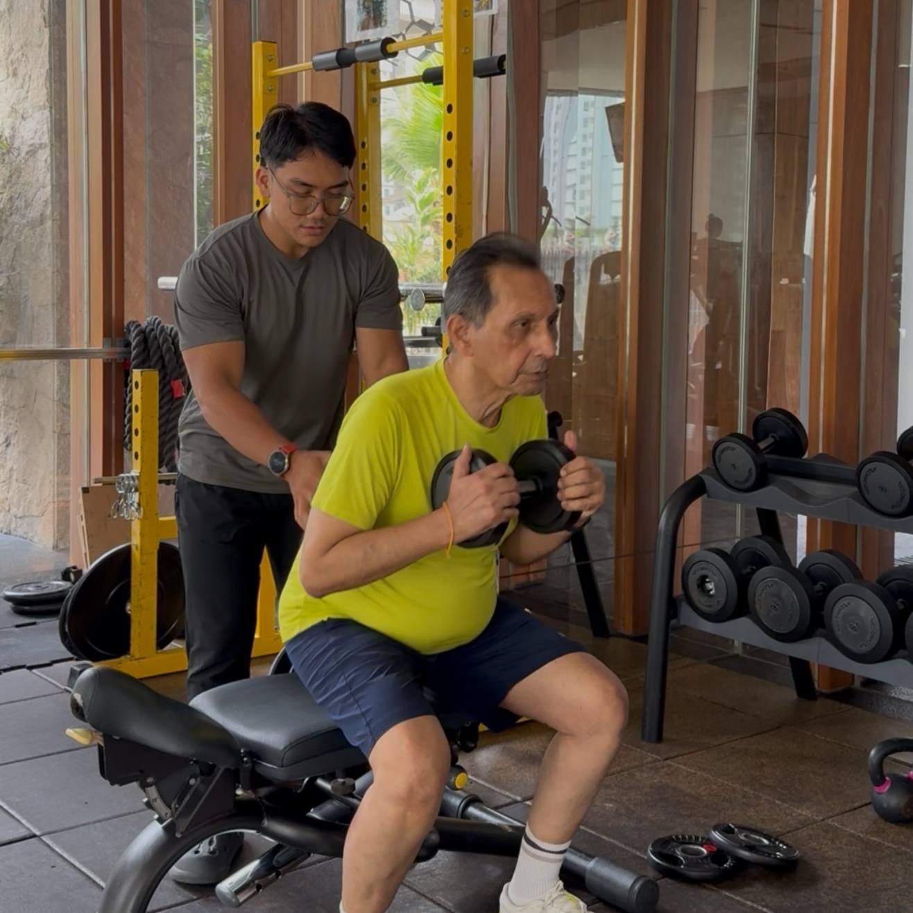 Faris supporting a client during a weighted squat to a bench
